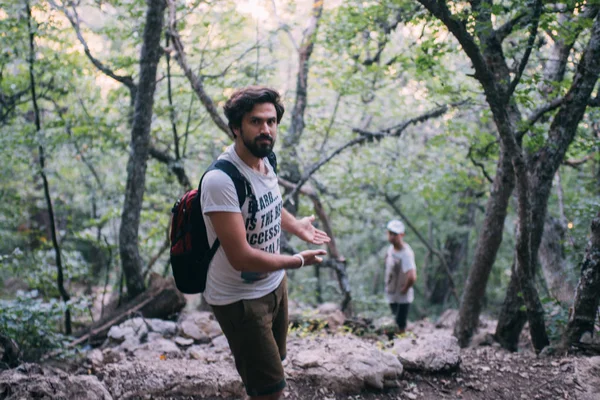 İki adam bir dağ yolunda yürüyor. 