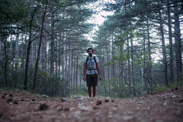 Un joven con una mochila en un viaje de senderismo por las montañas . —  Fotos de Stock