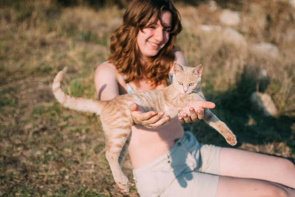 Mädchen spielt mit einer Katze im Freien. — Stockfoto