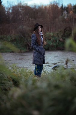 Bir kız bir bulutlu üzerinde köprü nehir kıyısında duruyor