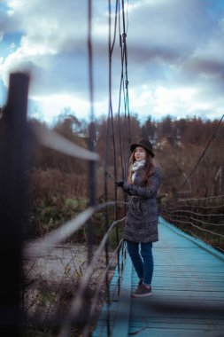 Köyde büyük bir asma köprü üzerinde genç kadın.
