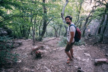 Bir sırt çantası bir yürüyüş gezisi dağlarda olan genç bir adam.