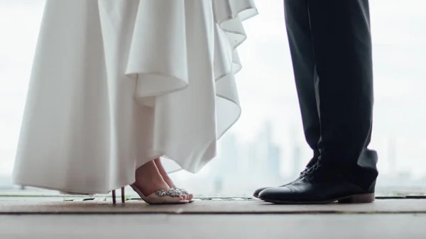 The legs of the bride and the feet of the groom — Stock Photo, Image