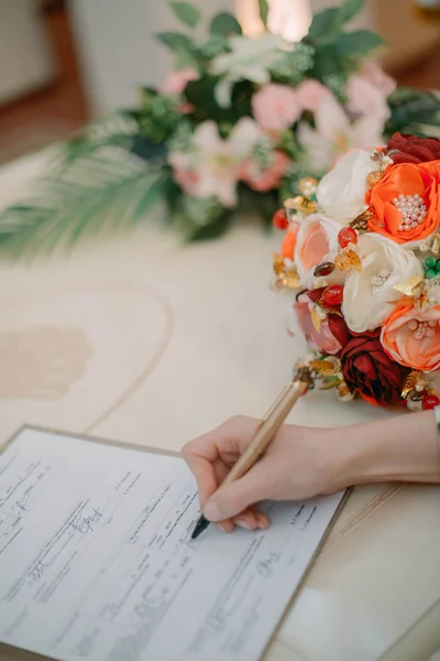 Newlyweds sign documents in the registry office on the wedding — Stock Photo, Image