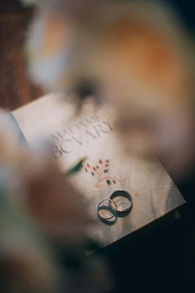 Los anillos de boda están en el viejo libro. primer plano — Foto de Stock