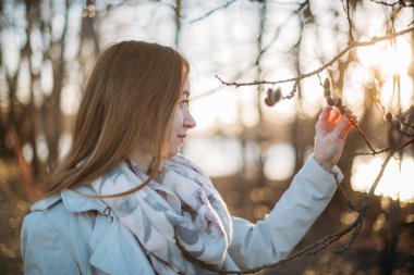 Sunse erken baharda söğüt dalları ile bir kızın portresi