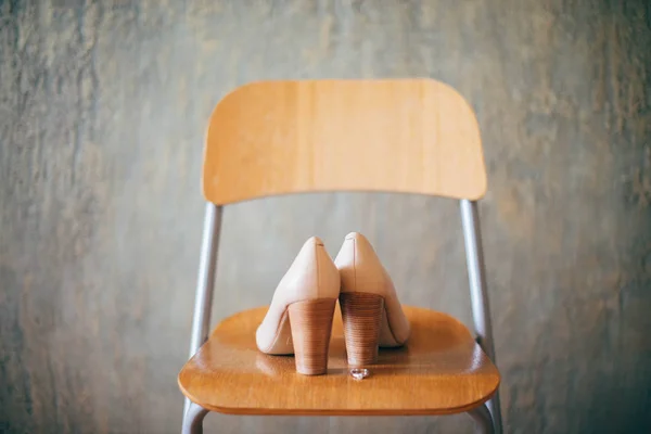 Bride\'s shoes on the chair in the hotel room in the morning