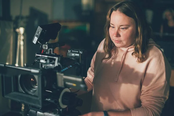 Girl cameraman behind camera on set