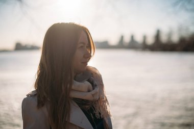 Kız baharda donmuş gölde duruyor.