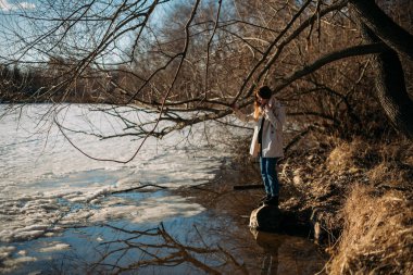 Kız baharda donmuş gölde duruyor.
