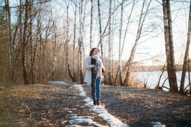 Bir kız son karda bir orman izi boyunca yürür.