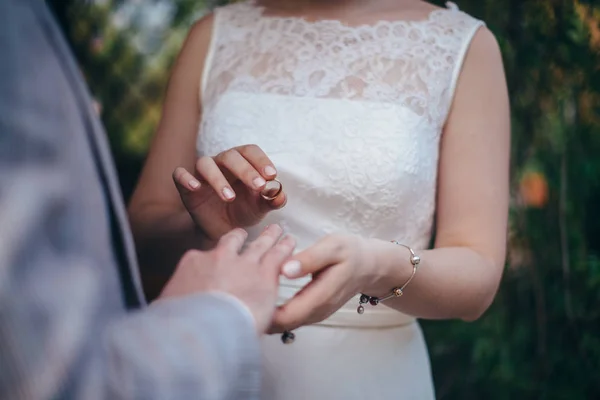 Um par de recém-casados na cerimônia de casamento usar alianças de casamento — Fotografia de Stock