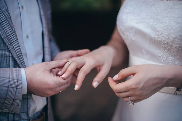 A couple of newlyweds at the wedding ceremony wear wedding rings — Stock Photo, Image