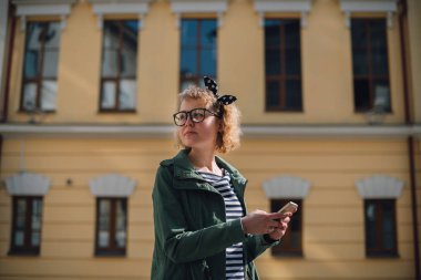 Elinde telefonla yol arayan genç bir turist. 