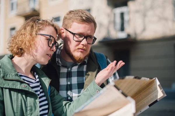 Ett ungt par turister söker en väg med en karta i — Stockfoto