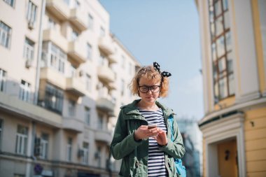 Elinde telefonla yol arayan genç bir turist. 
