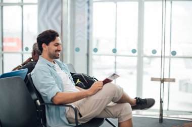 Sırt çantalı adam havaalanında oturuyor.. 