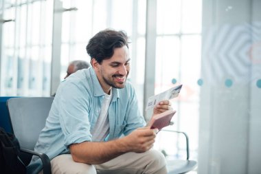 Sırt çantalı adam havaalanında oturuyor.. 