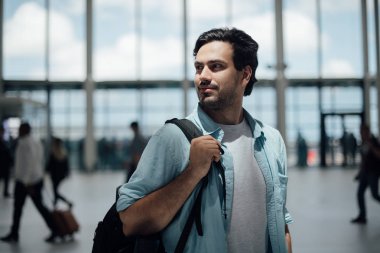 Havaalanında sırt çantası olan adam.