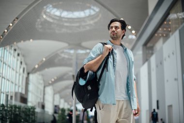 Havaalanında sırt çantası olan adam.