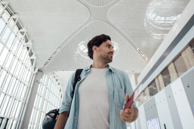 Havaalanında sırt çantası olan adam.