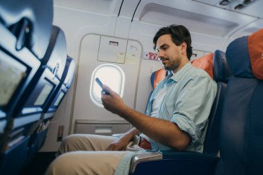 Adam elinde bir telefonla uçakta uçuyor.. 