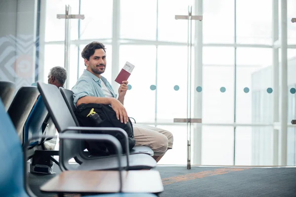 The guy with the backpack is sitting at the airport. — Stock Photo, Image