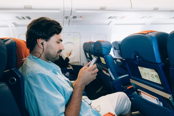 Парень летит на самолёте, слушает музыку. . — стоковое фото