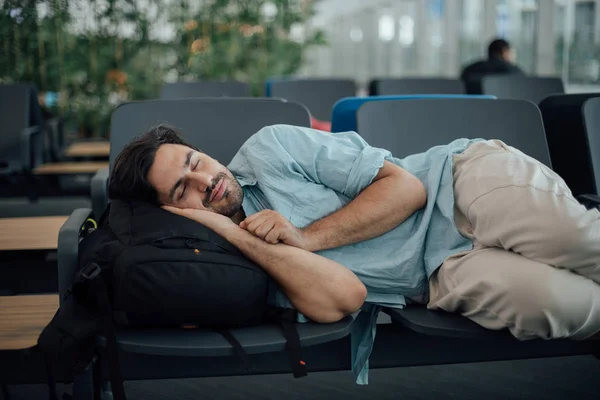 De man op de luchthaven wacht op vertrek, in slaap — Stockfoto