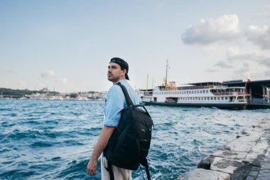 Denizin arka planına karşı genç bir adamın portresi, şehir,