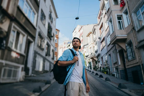 Um turista homem caminha pelas ruas com uma mochila — Fotografia de Stock