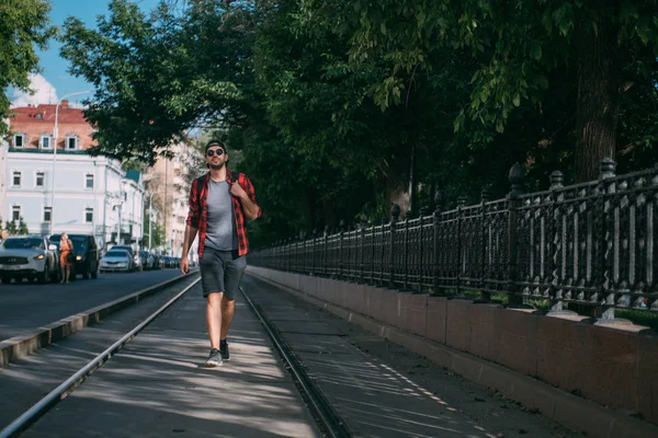 Человек-турист ходит по улицам с рюкзаком — стоковое фото