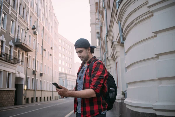 Un hombre está buscando una manera en el navegador en el teléfono mientras t — Foto de Stock