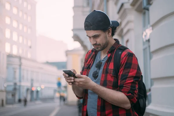 Un hombre está buscando una manera en el navegador en el teléfono mientras t — Foto de Stock