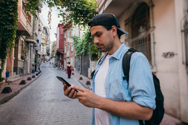 stock image A man is looking for a way in the navigator on the phone while t