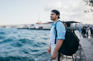 Denizin arka planına karşı genç bir adamın portresi, şehir,