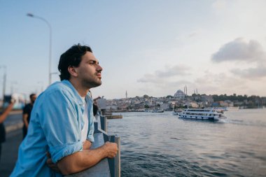 Köprüde genç bir adam şehrin uzaklığına bakıyor.. 