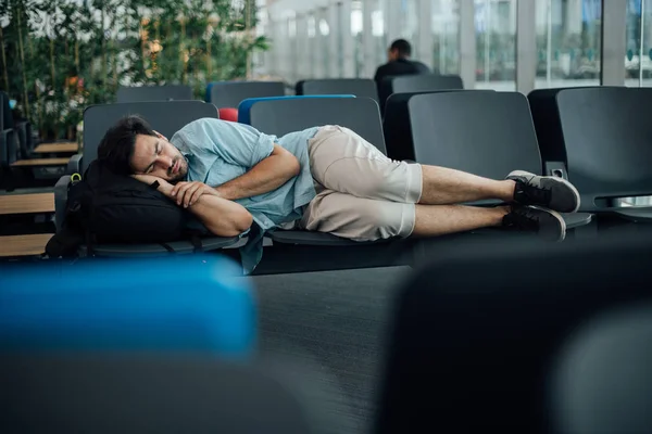 De man op de luchthaven wacht op vertrek, in slaap — Stockfoto