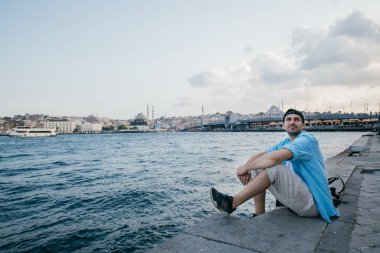 Denizin arka planına karşı genç bir adamın portresi, şehir,