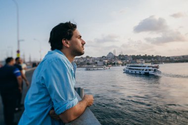 Köprüde genç bir adam şehrin uzaklığına bakıyor.. 