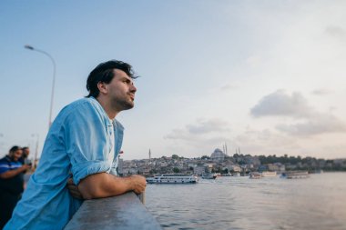 Köprüde genç bir adam şehrin uzaklığına bakıyor.. 