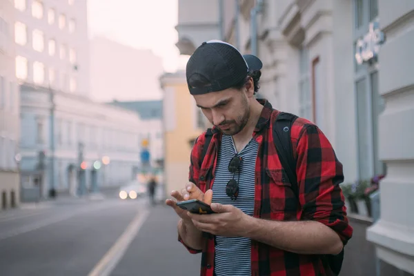 Un hombre está buscando una manera en el navegador en el teléfono mientras t — Foto de Stock