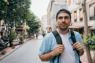 Bir adam turist bir sırt çantası ile sokaklarda yürür