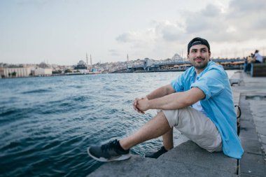 Denizin arka planına karşı genç bir adamın portresi, şehir,