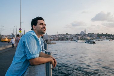 Köprüde genç bir adam şehrin uzaklığına bakıyor.. 