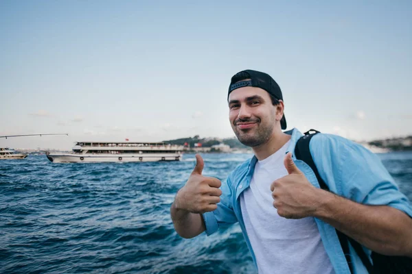 Portrait of a young man against the background of the sea, city, — Stock Photo, Image