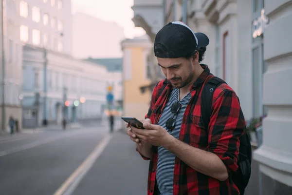 Un hombre está buscando una manera en el navegador en el teléfono mientras t — Foto de Stock