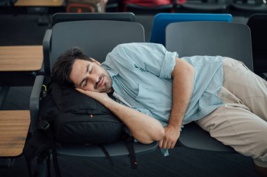 Havaalanındaki adam kalkışı bekliyor, uyuyor.