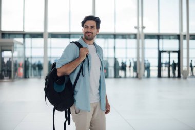 Havaalanında sırt çantası olan adam.