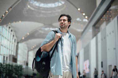 Havaalanında sırt çantası olan adam.